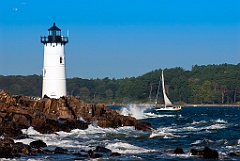 Portsmouth Lighthouse Guides Sailboat Away From Rocky Shore